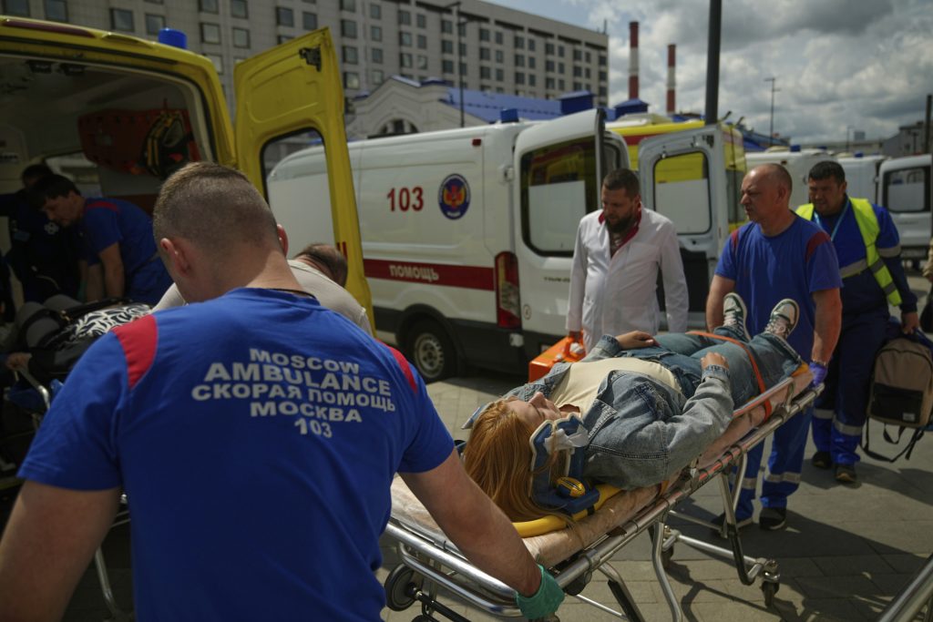 Záchranári prevážajú zraneného cestujúceho po tom, čo sa cestný most zrútil na osobný vlak v Brjanskej oblasti v nedeľu 1. júna 2025 (Foto: SITA/AP Photo)